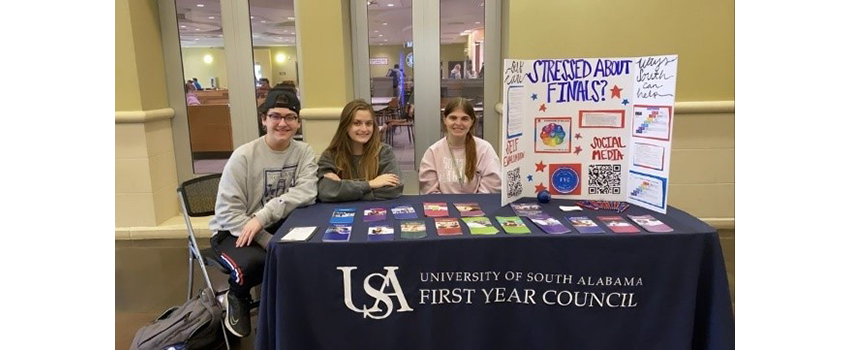 Peer counselors in student center with table set up for information for students.