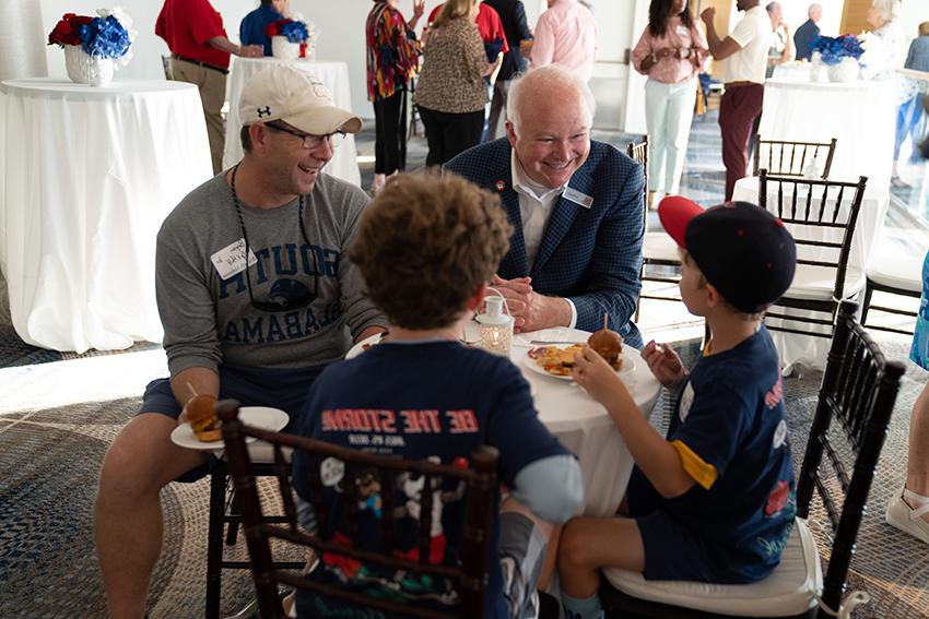 邦纳总统和他们的父亲在活动上对小男孩讲话.