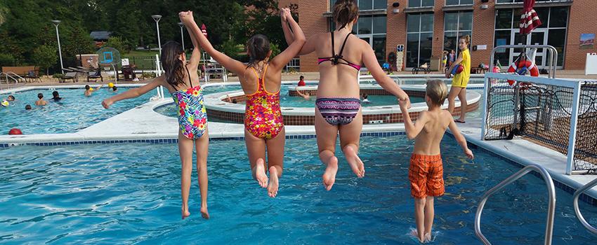 孩子们在学生娱乐中心的室外游泳池里跳跃.