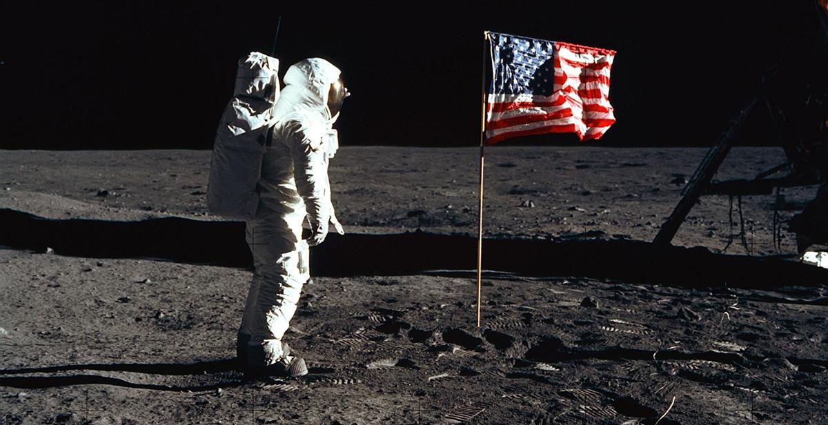宇航员Edwin "Buzz" E. 奥尔德林小., 第一次登月任务的登月舱飞行员, 在展开的美国国旗旁摆姿势拍照. 美国国家航空航天局的照片.  